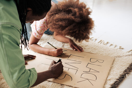 Girl and her father preparing a banner for Black lives matter protests