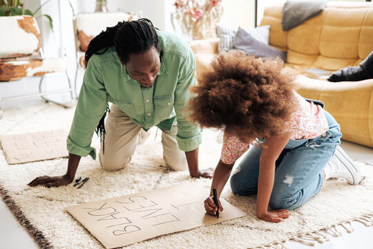 Girl and her father preparing a banner for Black lives matter protests at home