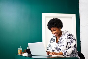 black smiling worker on computer