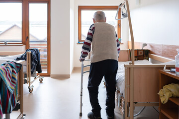 Senior Man Walking With Walker In Ward