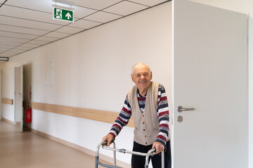 Happy Senior Man With Walker At Corridor