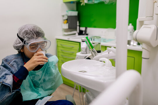 Teen boy drinking water during dental procedure