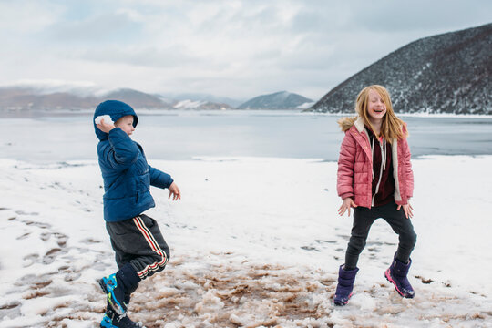 Two kids play in the snow on a high plateau 