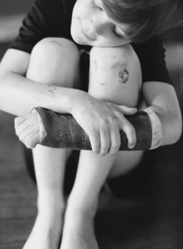young boy has broken arm and skinned knee