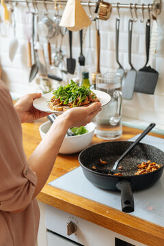 Woman holding plate of snack with ruccola