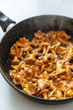 Steaming aromatic chanterelle mushrooms in pan