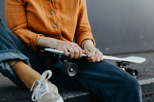 Girl with skateboard in industrial area