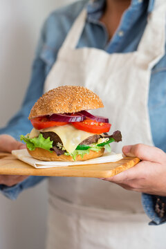Woman holding a grilled hanburger