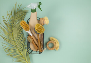Wooden bamboo and coconut brushes for dishwashing, bathroom and home cleaning on pastel mint background. Eco-friendly zero waste lifestyle concept, reusable and recycling tools for house work. 