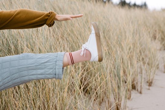 Trendy Young woman's leg wearing blue pants and white sneakers 