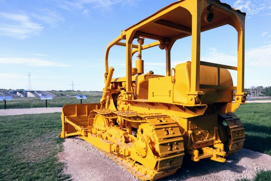 Close-up of a non-functioning bulldozer painted entirely in yellow paint