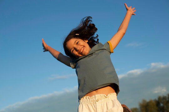 Beautiful, jumping girl on a blue sky background