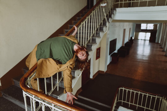 
Red-haired young guy leaned against the pirils