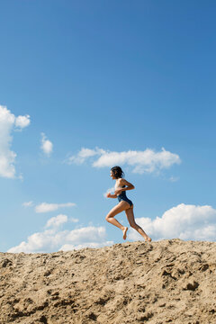 Cute girl is running on a sand 