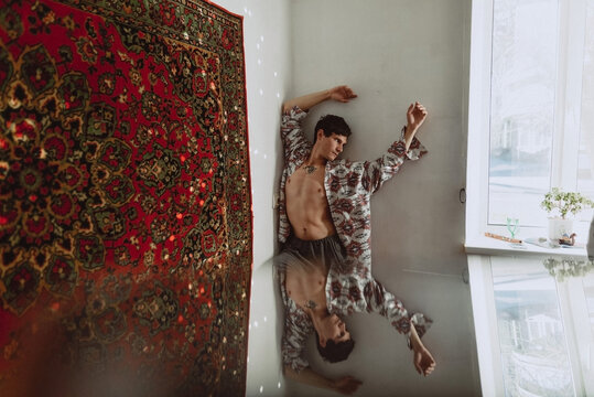 Young man dancing on a white wall background