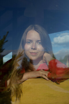 Portrait of a beautiful girl through a window 