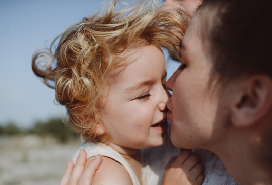 young woman kissing her son on the nose
