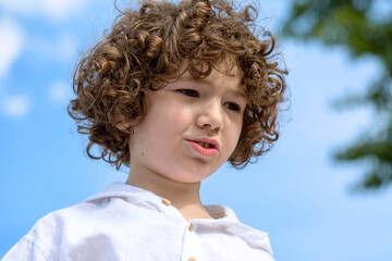 Portrait of a cute little boy with a curly hair.
