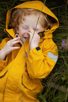Cute, little boy with a curly, ginger hair outdoors