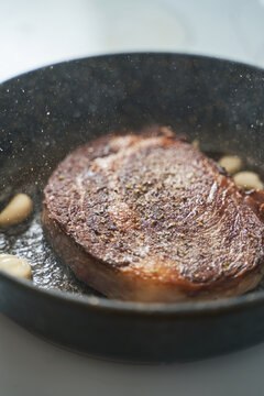 Fried meat with garlic on pan
