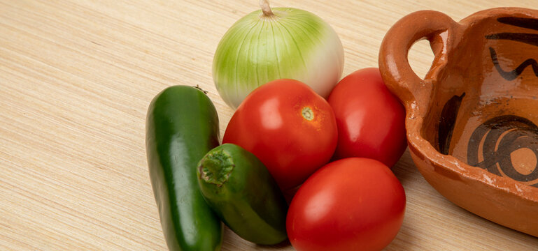 chiles, cebolla y jitomates para hacer salsa Mexicana sobre una mesa