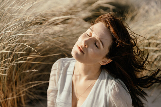 Woman in grassy sand dunes