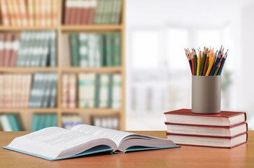 School table with books, stationery in the blurred study room