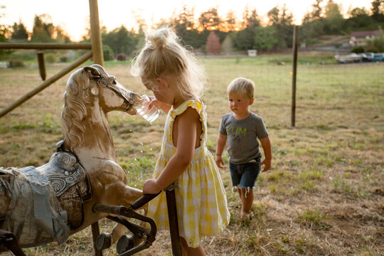 Children give  toy horse a drink of water