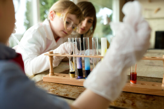 Children examine test tubes full of bubbling liquid.