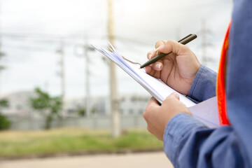 Hand holding clipboard and write on document checklist high voltage system, Working woman