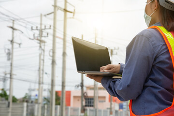 Female Engineer holding laptop working outdoor. Worker Woman use computer technology