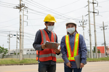 Two Engineer teamwork wear face mask protect coronavirus covid19