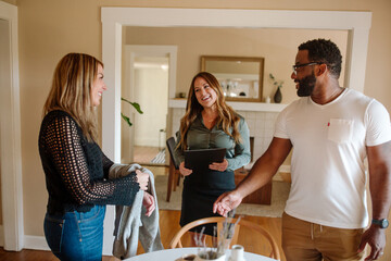 Smiling biracial couple with real estate agent