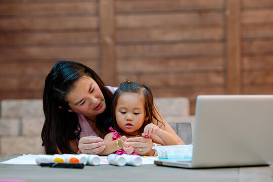 Asian-American mom helping preschooler 