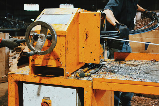 Workers at a Recycling Factory Using A Machine For Metal