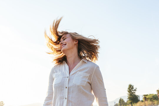 Playful portrait of young woman shaking her hair