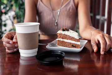 Crop woman at table with coffee and dessert