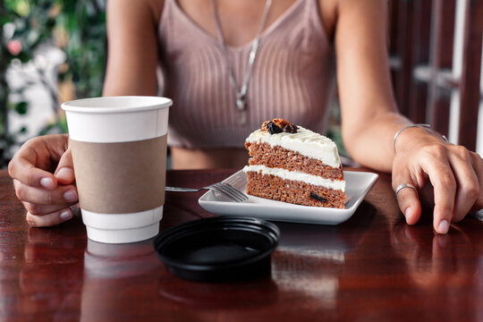 Crop woman at table with coffee and dessert