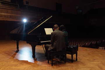 Man and woman, playing a piano