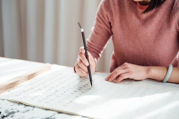 Asian woman writing calligraphy