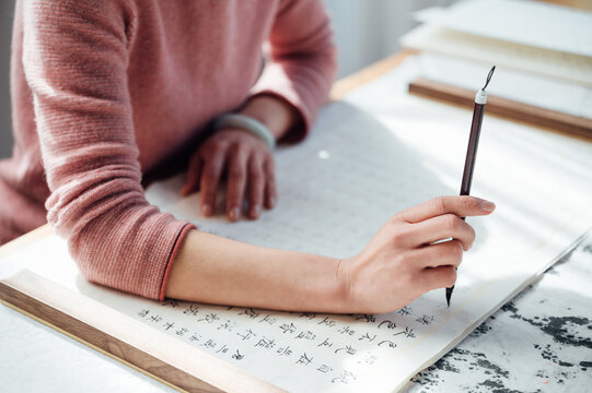 Asian woman writing calligraphy