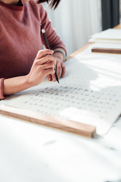 Asian woman writing calligraphy