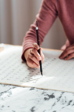 Asian woman writing calligraphy