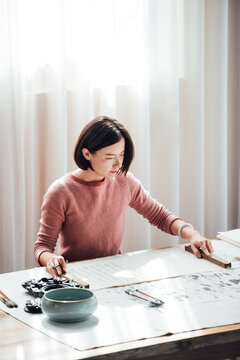 Asian woman writing calligraphy