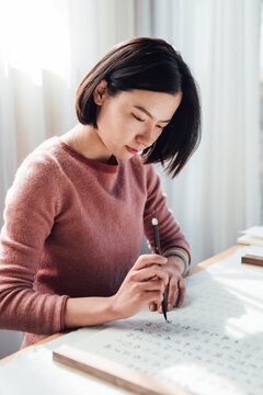 Asian woman writing calligraphy