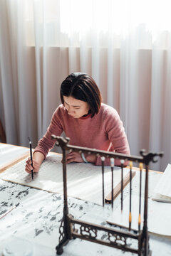 Asian woman writing calligraphy
