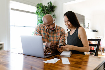 Young Couple Looks at Credit Card and Receipts