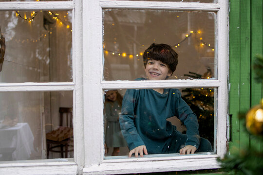 Little boy looking through the window