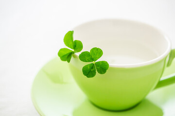 四つ葉のクローバーとコーヒーカップ