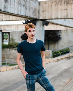 Portrait of young androgyne man standing in contrete stairs 